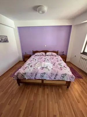 a bedroom with a bed with a purple wall at Yovkovata Kyshta in Chiflik