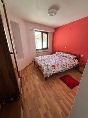 a bedroom with a bed and a red wall at Yovkovata Kyshta in Chiflik