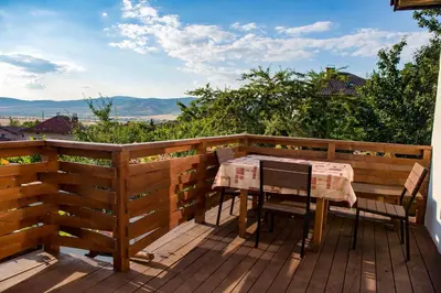 a wooden deck with a table and chairs on it at Sapareva Kashta in Sapareva Banya