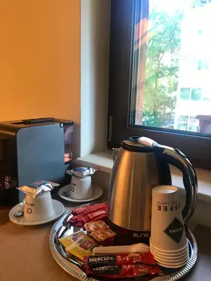 a tea kettle and cups on a table next to a window at Sofia Family House - Free Parking in Sofia