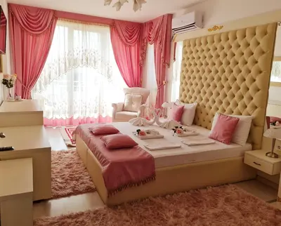 a bedroom with a large bed with pink curtains at Hotel Dalia - Bankya in Bankya
