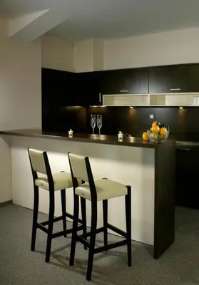 a kitchen with two chairs and a bar with a counter at Kendros Hotel in Plovdiv