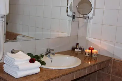 a bathroom with a sink and a mirror and towels at Kendros Hotel in Plovdiv