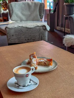 a cup of coffee and two pastries on a table at Family Hotel EDI in Sofia