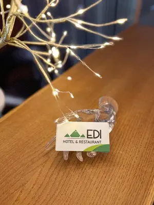 a sign for a hotel and restaurant on a table at Family Hotel EDI in Sofia