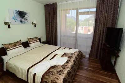 a bedroom with a bed and a television and a window at Guesthouse Nefertiti in Smolyan