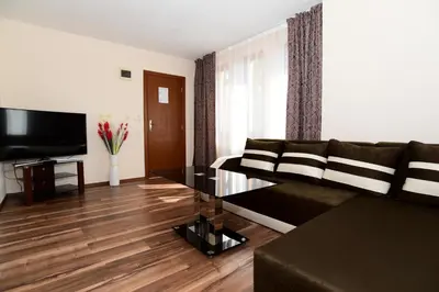 a living room with a couch and a television at Guesthouse Nefertiti in Smolyan