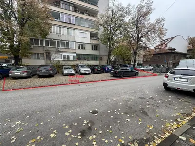 a parking lot with cars parked in front of a building at Apartment Trimontium in Plovdiv