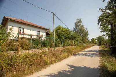 a dirt road next to a house with a fence at Вила Бойковец in Boykovets