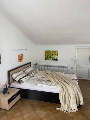 a bedroom with a large bed with a blanket on it at Art Studio in Sapareva Banya