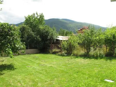 a yard with a fence and green grass at Guest House Vergie, Fully Private in Sapareva Banya