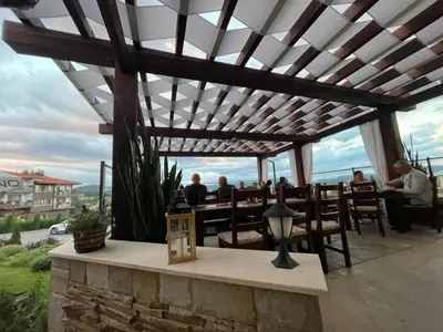 people sitting at a restaurant under a pergola at Family Hotel Eterno in Tsigov Chark