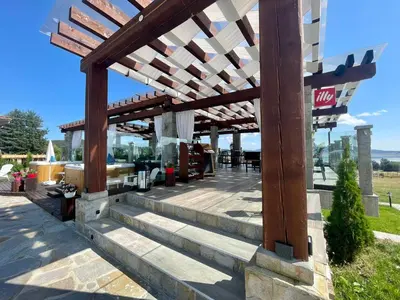 a patio with a wooden pergola and stairs at Family Hotel Eterno in Tsigov Chark