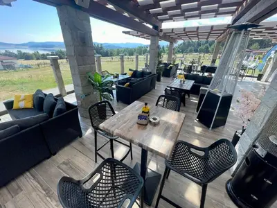 a patio with a table and chairs and a couch at Family Hotel Eterno in Tsigov Chark