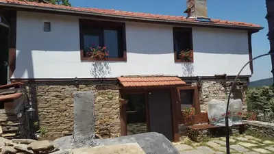a stone house with two windows and a door at Pisanata House in Dedovo
