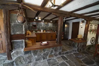 a large kitchen with wooden cabinets and a stone wall at Pisanata House in Dedovo