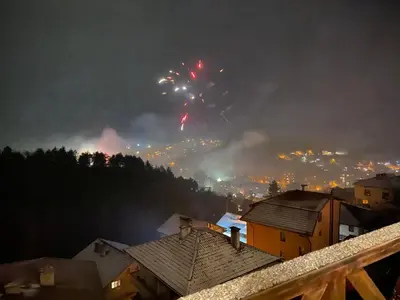 a fire in a city with fireworks in the sky at Planinski Polah House in Devin