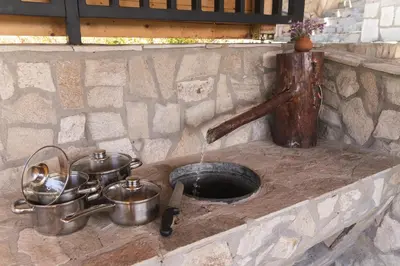 a kitchen sink with pots and pans on a stone counter at Planinski Polah House in Devin