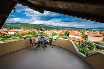 a balcony with chairs and a table with a view at Guest House Holiday in Ognyanovo