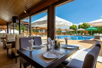 a dining room with a table and a pool at The Balkan Jewel Resort, Trademark Collection by Wyndham in Bansko