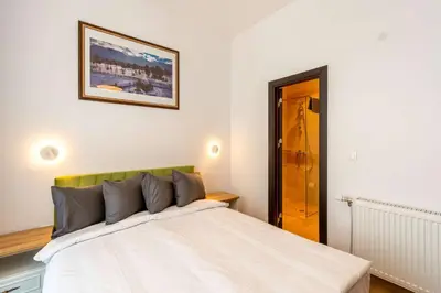 a bedroom with a white bed with a picture on the wall at The Balkan Jewel Resort, Trademark Collection by Wyndham in Bansko