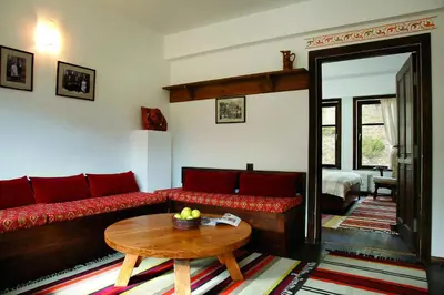 a living room with a red couch and a table at Family Hotel Arkan Han in Trigrad