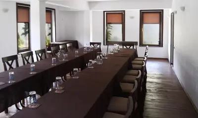 a row of tables and chairs in a room with windows at Family Hotel Arkan Han in Trigrad