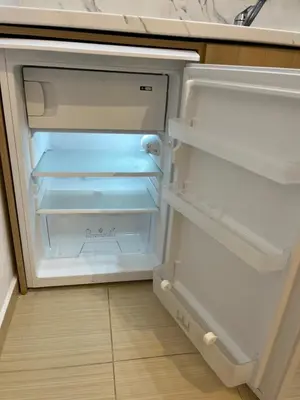 an empty refrigerator with its door open in a kitchen at Borovets Gardens Chalet Flat in Borovets
