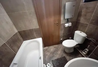 a bathroom with a tub and a toilet and a sink at PM Services Sequoia Apartment in Borovets