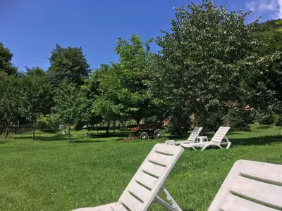 two white lawn chairs sitting in the grass at Бунгала Дара in Kalofer