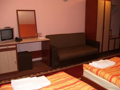 a hotel room with a couch and a mirror at Kestenite Family Hotel in Samokov