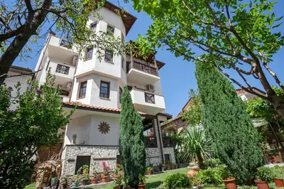 a building with trees in front of it at Keremidchieva Kushta Guest House in Sandanski