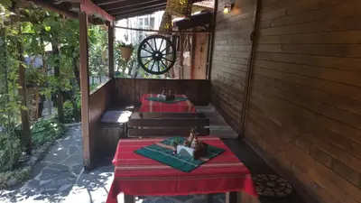 two tables with red table cloths on a patio at Keremidchieva Kushta Guest House in Sandanski