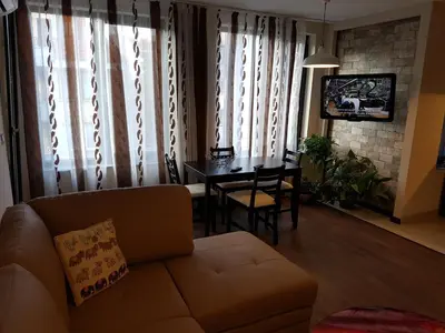 a living room with a couch and a dining room table at Apartments Sofia Yavorov in Sofia