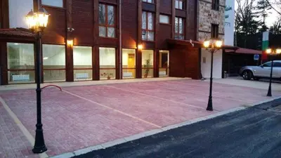 a parking lot in front of a building with two lights at Mountain View Resort Studio in Bansko