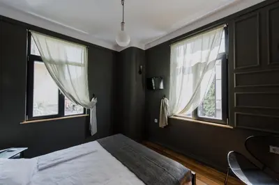a bedroom with black walls and two windows at Mouse House Kapana in Plovdiv