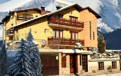 a large building with a tree in front of it at Mavrikova Kushta in Bansko