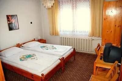 a bedroom with a bed and a chair and a window at Mavrikova Kushta in Bansko