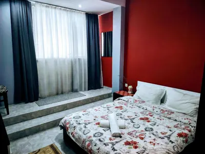 a bedroom with a bed with a red wall at Apartment Diana in Resilovo