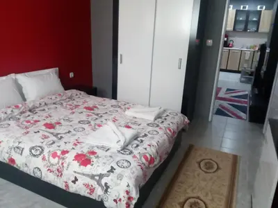a bedroom with a bed with a red and white blanket at Apartment Diana in Resilovo