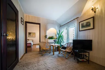 a living room with a television and a table and chairs at Sunny Apartment Sofia in Sofia