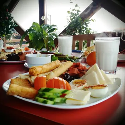 a plate of cheese and other food on a table at Grand Monastery Private Apartments in Pamporovo
