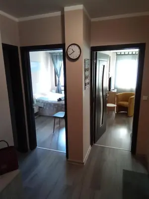 a room with a clock on the wall and a bedroom at Apartment 46 in Sofia