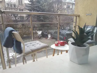 a chair and a potted plant on a balcony at Apartment 46 in Sofia