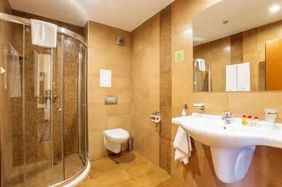 a bathroom with a sink and a shower and a toilet at Sofia Place Hotel by HMG in Sofia