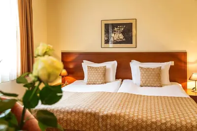 a bedroom with a bed with white sheets and pillows at Sofia Place Hotel by HMG in Sofia