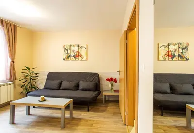 a living room with a couch and a table at Sofia Place Hotel by HMG in Sofia