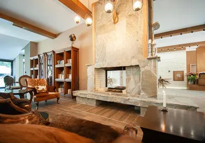 a living room with a large stone fireplace at Park Hotel Ela in Borovets