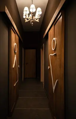 a hallway with wooden doors and a chandelier at Park Hotel Ela in Borovets
