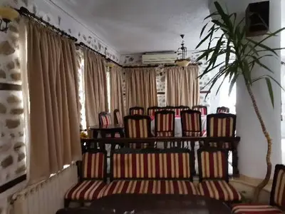 a group of chairs in a room with curtains at Hotel Bolyarka in Melnik